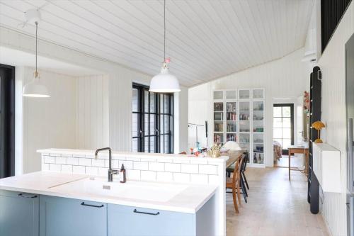 a white kitchen with a sink and a table at 10045-1-Rorvig-Birkebakken-3 in Rørvig