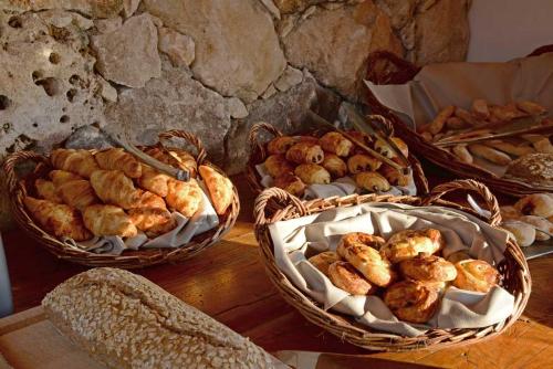 three baskets of bread and pastries on a table at Hôtel Le Belvédère in Porto-Vecchio