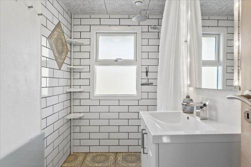 a white bathroom with a sink and a window at LF14223-Roslev-Livovej-9 in Roslev
