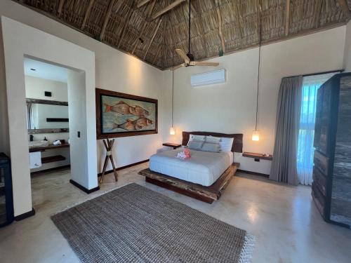 a bedroom with a bed and a television in it at Flamingo Blue - Casa Boutique - Adults Only in El Cuyo