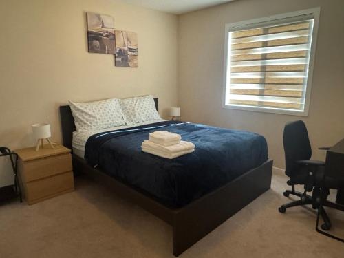 a bedroom with a bed with blue sheets and a window at Peace Home in Calgary