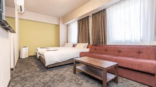 a hotel room with a bed and a couch at Hotel Nagano Avenue in Nagano