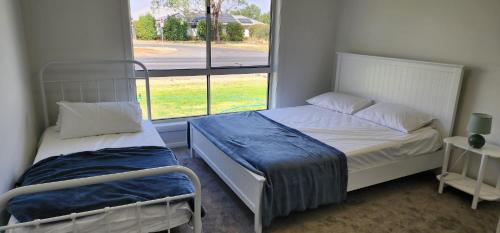 a small bedroom with two beds and a window at Room In Dubbo With Queens Beds in Dubbo