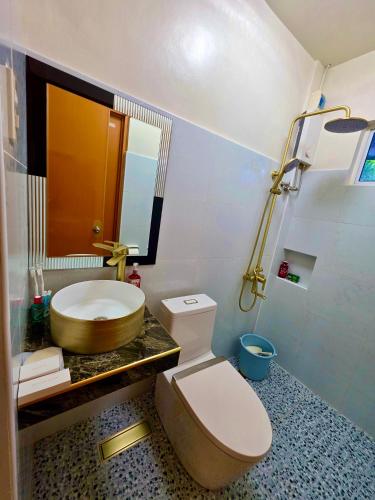 a bathroom with a toilet and a sink at Nice Whitepebbles Beach Front in Sibulan