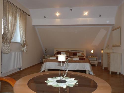 ein Schlafzimmer mit einem Bett und einem Tisch mit einer Blume darauf in der Unterkunft Zielona Dolina in Nowogródek Pomorski