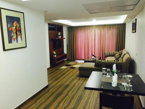 a living room with a couch and a table at KGA Elite Continental Hotel in Thiruvalla