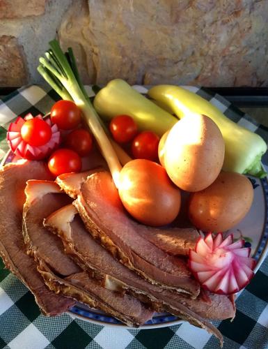 a plate of meat and vegetables on a table at Flórián Vendégház in Villánykövesd