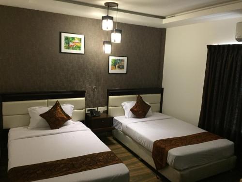 a hotel room with two beds in a room at KGA Elite Continental Hotel in Thiruvalla