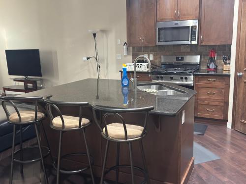 a kitchen with a counter with four bar stools at Peace Home in Calgary