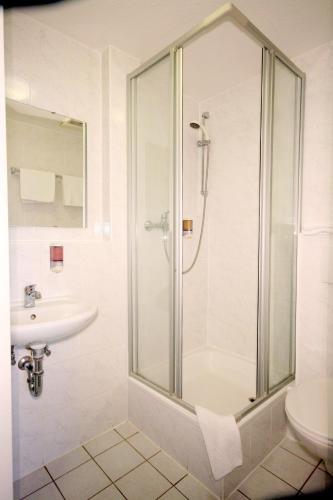 a bathroom with a shower and a sink at Classic Inn in Heidelberg