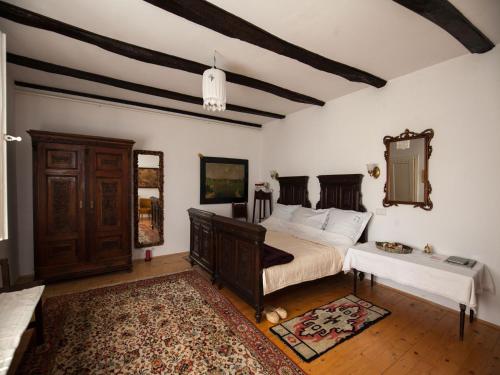 1 dormitorio con cama, mesa y espejo en Kurija Inn, en Hrašćina