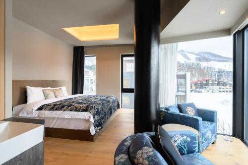 a bedroom with a bed and a large window at HOTELA Niseko Towers in Kutchan