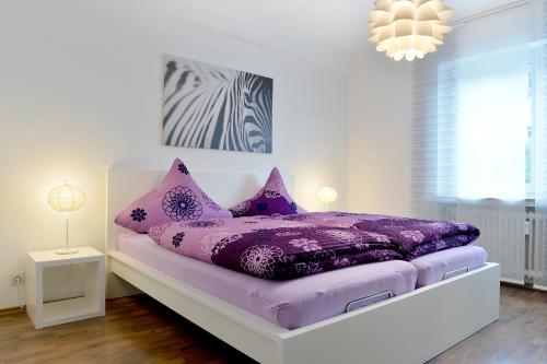 a purple bed with purple pillows in a white room at Haus Daniela Superior in Cochem