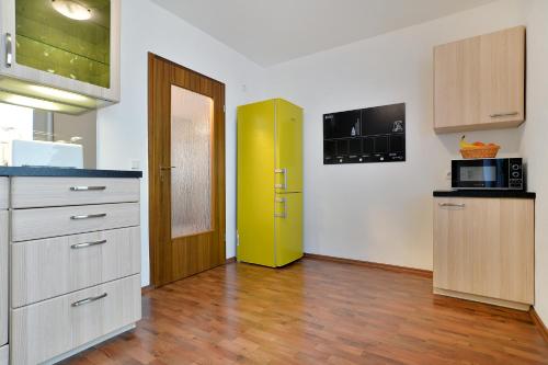 a kitchen with a yellow door and a kitchen with wooden floors at Haus Daniela Superior in Cochem