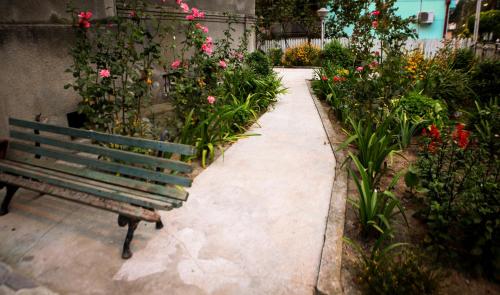 a bench sitting next to a garden with flowers at White Hotel Guesthouse in Zugdidi
