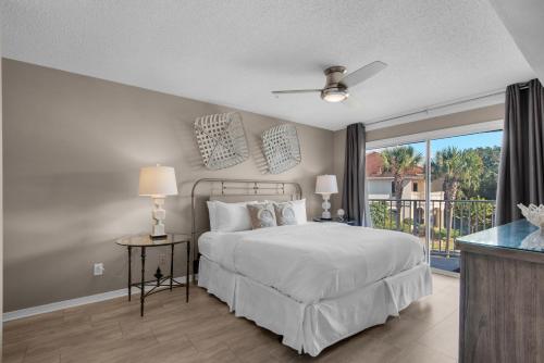 a bedroom with a bed and a balcony at Emerald Gulf Escape at Miramar Beach in Destin