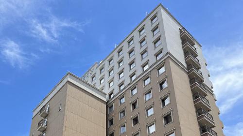 a tall building with a blue sky in the background at Toyoko Inn Kumamoto Shin-shigai in Kumamoto