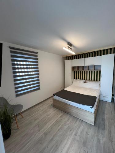 a bedroom with a large bed and a window at Luxus Cluj Airport Apartments in Cluj-Napoca