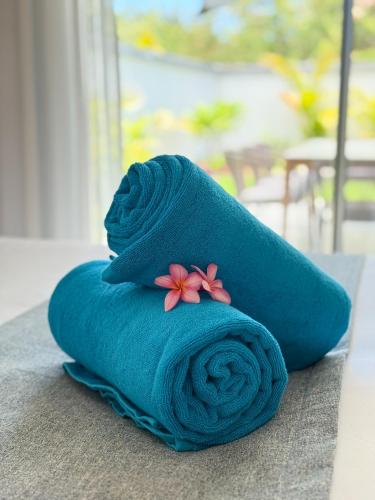 a blue towel with a flower on top of it at North Island View Family Duplex with private pool by LOV Mauritius in Grande Gaube