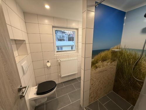 a bathroom with a shower with a toilet and a window at Ferienhaus Pank in Heringsdorf