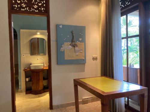 a bathroom with a sink and a table and a mirror at Gunung Paradis Retreat in Munduk