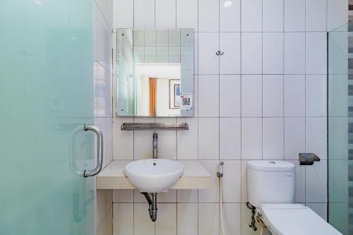 a bathroom with a sink and a toilet and a mirror at SANS Vibes Hotel Igloo Cikarang in Cibitung