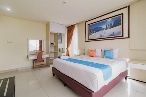a bedroom with a large bed in a room at SANS Vibes Hotel Igloo Cikarang in Cibitung