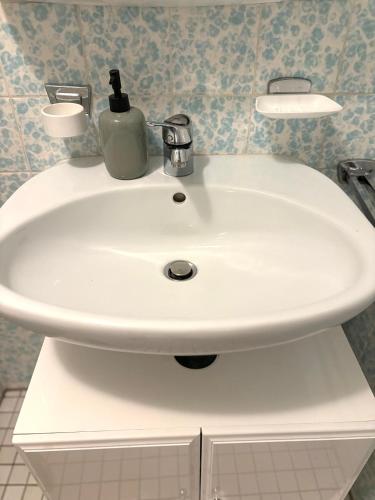 a white bathroom sink with a soap dispenser on it at Ferienwohnungen an der RupertusTherme in Bad Reichenhall