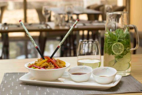 a plate with bowls of food and a glass of water at İstanbul Medikal Termal in Tuzla