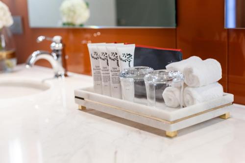 a towel rack with towels and toiletries on a bathroom counter at La Seine Boutique Hotel in Vientiane