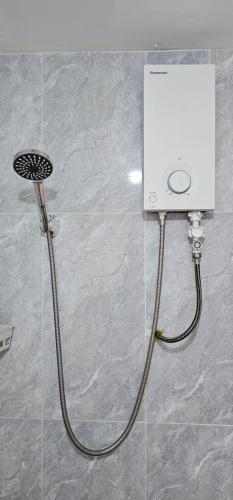 a shower with a hose attached to a wall at The Bay Lookout in Kaôh Rŭng (3)