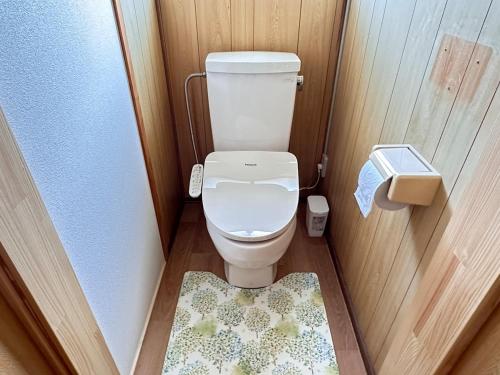 a small bathroom with a toilet and a rug at さくらもり in Nagano