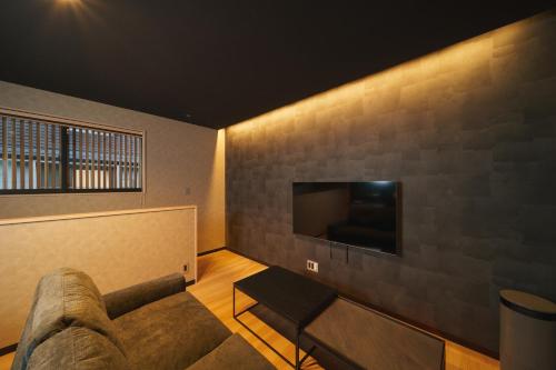 a living room with a couch and a flat screen tv at 雅音 GAON - Beppu in Beppu