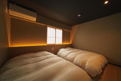 a bedroom with a large bed and a window at 雅音 GAON - Beppu in Beppu