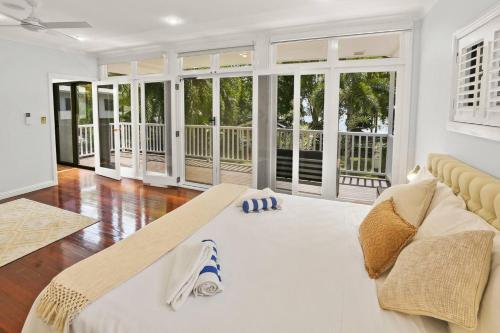 a large living room with a couch and windows at Willow Garden Stays Cairns - Beachfront 4 Bedroom Luxury Holiday Home in Kewarra Beach