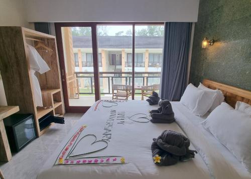 a hotel room with a bed with stuffed animals on it at Pine Tree Beach Hotel in Gili Trawangan