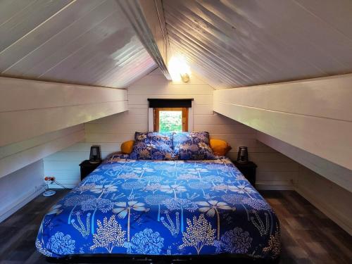 a bedroom with a blue bed in a attic at Climatisation avec La Rouyonnaise in Tinténiac