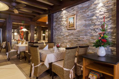 un ristorante con tavoli e sedie e un muro di mattoni di Zum Fässle a Hagnau