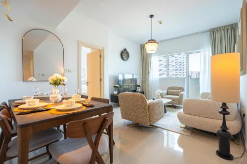 a living room with a dining room table and chairs at Chic 2BR - Bright Balcony Bliss in Al Reem in Abu Dhabi