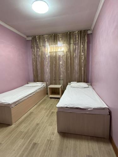 two beds in a room with pink walls at Гостиница"Hostel" in Karagandy