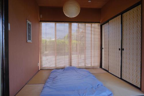 a large bed in a room with a large window at スローライフ喜界 in Onozu