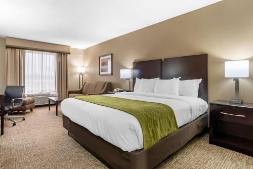 a hotel room with a large bed with a green blanket at Comfort Inn Pearl-Jackson in Pearl