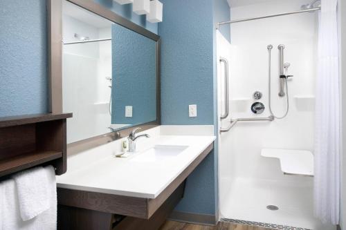 a bathroom with a sink and a shower at Woodspring Suites Orlando International Drive in Orlando