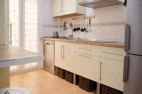 a kitchen with white cabinets and a sink at Brisa Chilches nº 5 in Málaga