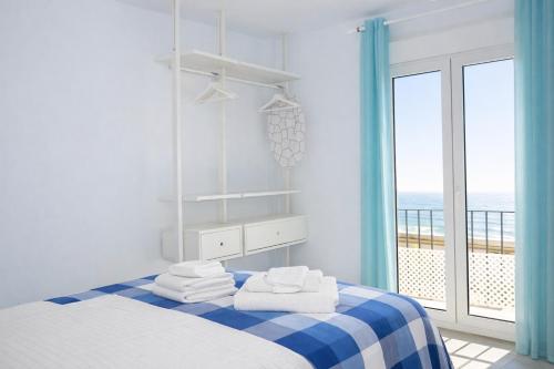 a bedroom with a bed with towels and a view of the ocean at Brisa Chilches nº 5 in Málaga