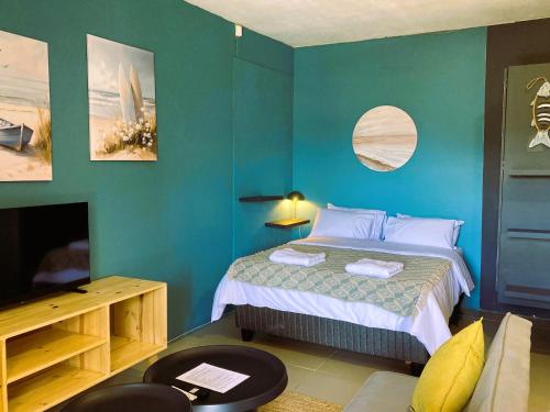 a blue bedroom with a bed and a tv at Luxury Smart Studio - Sea and Mountain Views - Gordon's Bay in Gordonʼs Bay