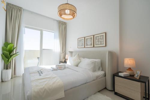 a white bedroom with a large bed and a window at Chic 2BR - Bright Balcony Bliss in Al Reem in Abu Dhabi