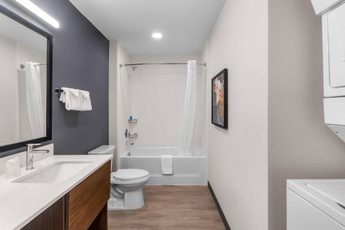a bathroom with a sink and a toilet and a tub at Everhome Suites Clarksville Ft Campbell Area by Choice Hotels in Clarksville