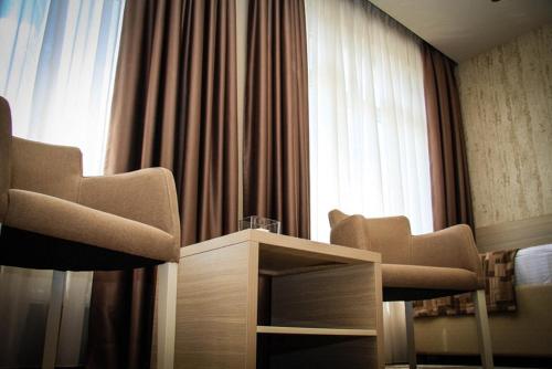 a room with two chairs and a table and a window at Hotel Palazzo in Gornji Vakuf