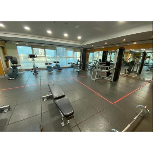a gym with chairs and machines in a building at Chic 2BR - Bright Balcony Bliss in Al Reem in Abu Dhabi